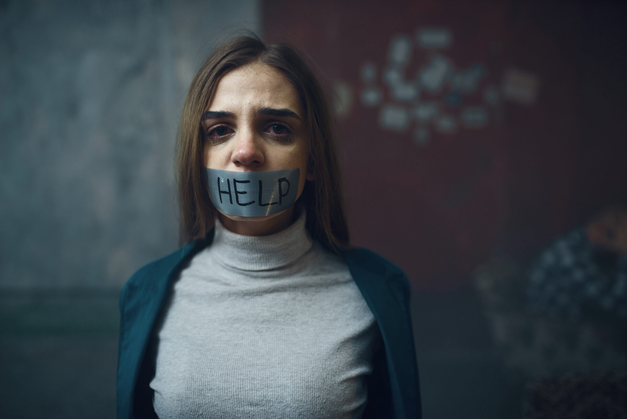 Female victim of maniac kidnapper with her mouth taped shut. Kidnapping is a serious crime, kidnap horror, violence. Kidnapping lawyer should be contacted. 